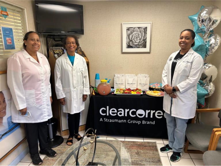 Doctors standing in front of a clear correct display with snacks and punch